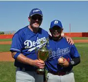 Two baseball Players in Blue Shirts Holding a Trophy