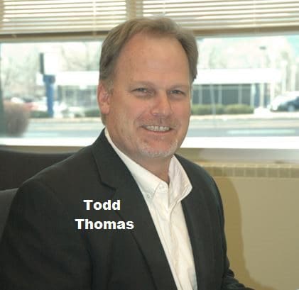 Todd Thomas in a Black Coat Smiling