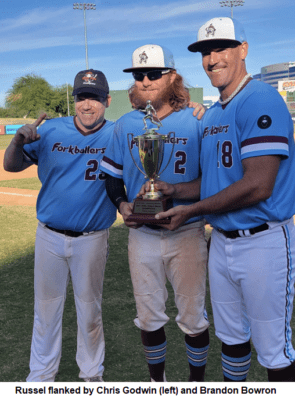 Three Men in Matching Blue Baseball Tops With a Trophy