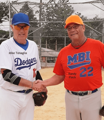 Two baseball players shaking hands on a baseball field.