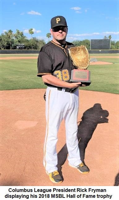 A man holding a trophy while holding a baseball bat.