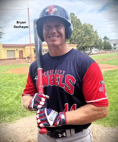 A smiling baseball player in a red and navy uniform, holding a bat on a field, with the name "bryan deshayes" labeled above.