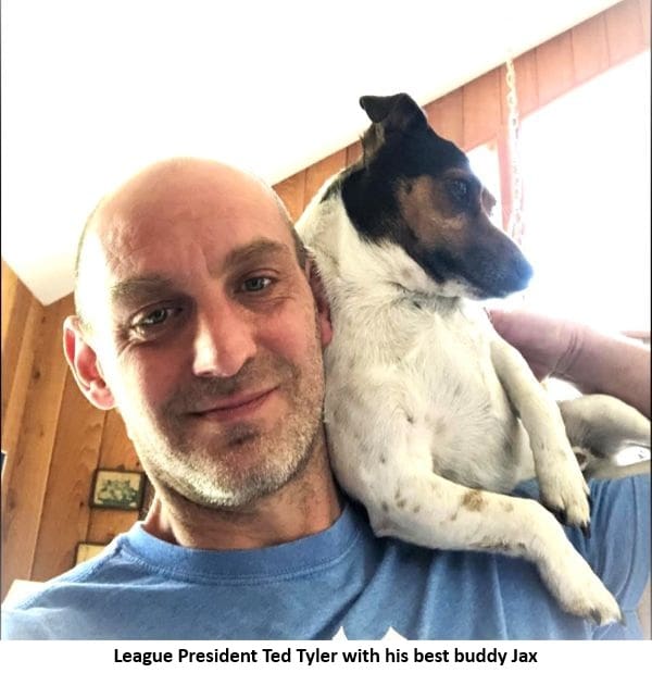 Man smiling with small dog on shoulder.