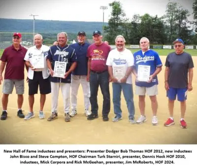 Seven men posing on a baseball field.