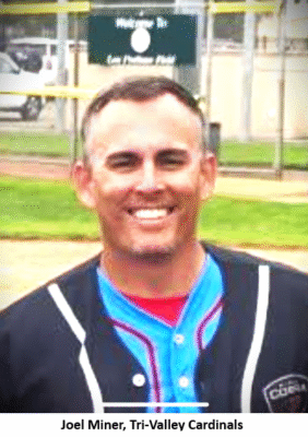 Smiling man in baseball uniform outdoors.