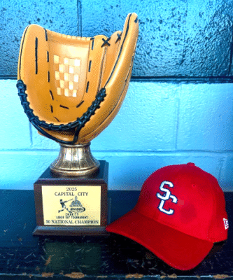 Trophy and red baseball cap on bench.
